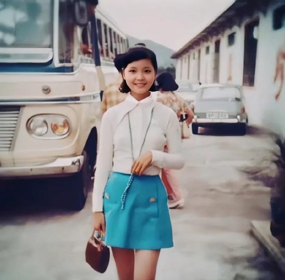 这张照片拍摄于1969年，甜歌皇后邓丽君在香港街头的留影旧照，照片中的邓丽君穿着