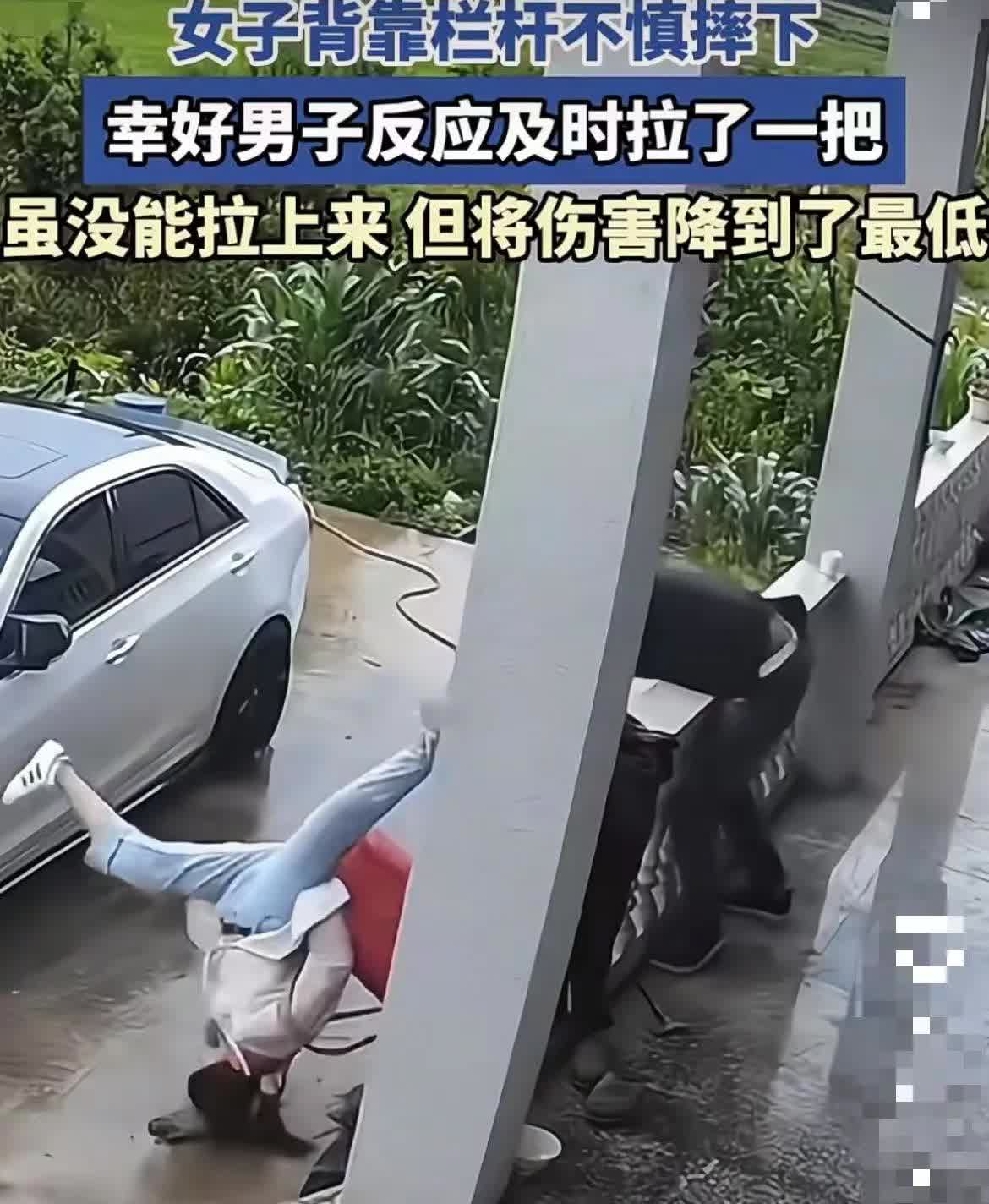 惊险瞬间！女子背靠着栏杆时不小心向后摔落，旁边的男子反应敏捷，马上伸手去拽。虽然