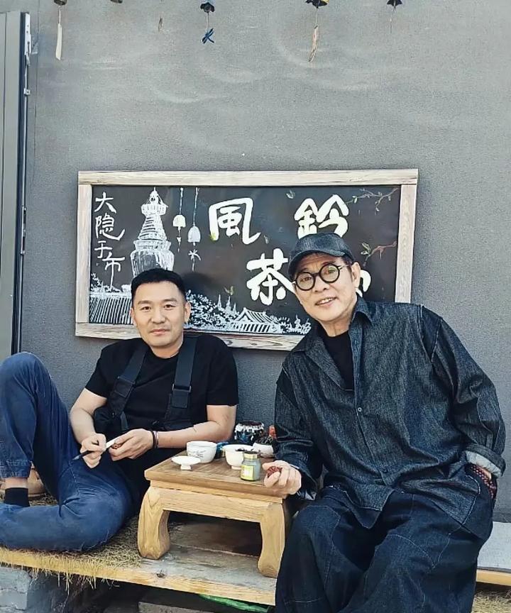 李连杰穿着一套休闲套装，戴着帽子，一副眼镜，帅气又休闲，一看就是硬汉一枚，妥妥的