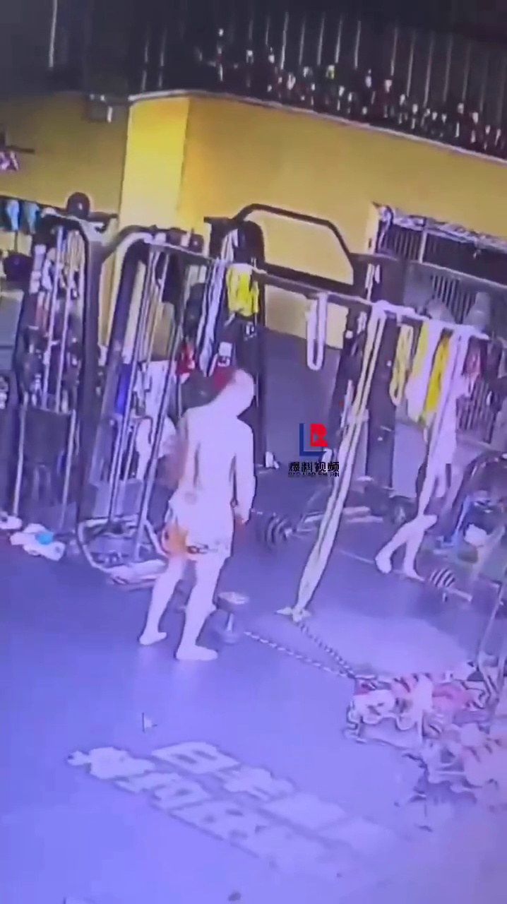 一男子健身房站在哑铃上把绳子套在脖子上随后身体悬空挂在上边！