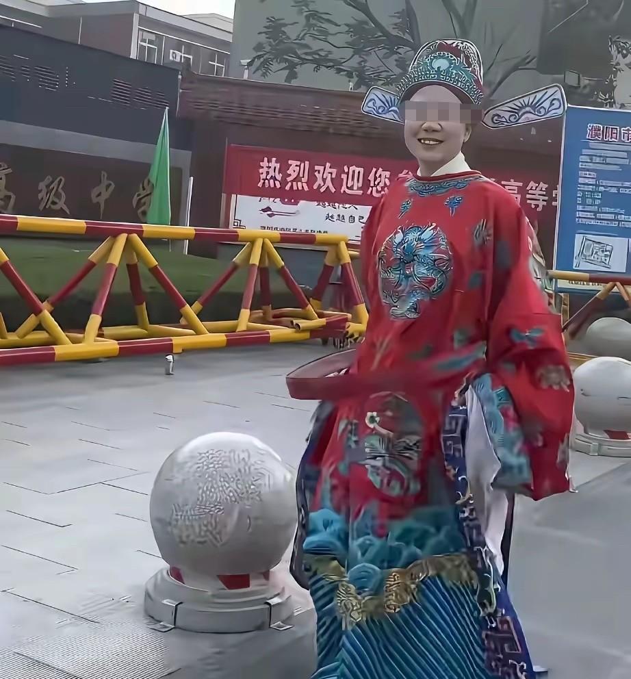 这是两位不同的妈妈，她们都是在陪着孩子高考。
图一的这位妈妈穿上龙袍蟒带，等着孩