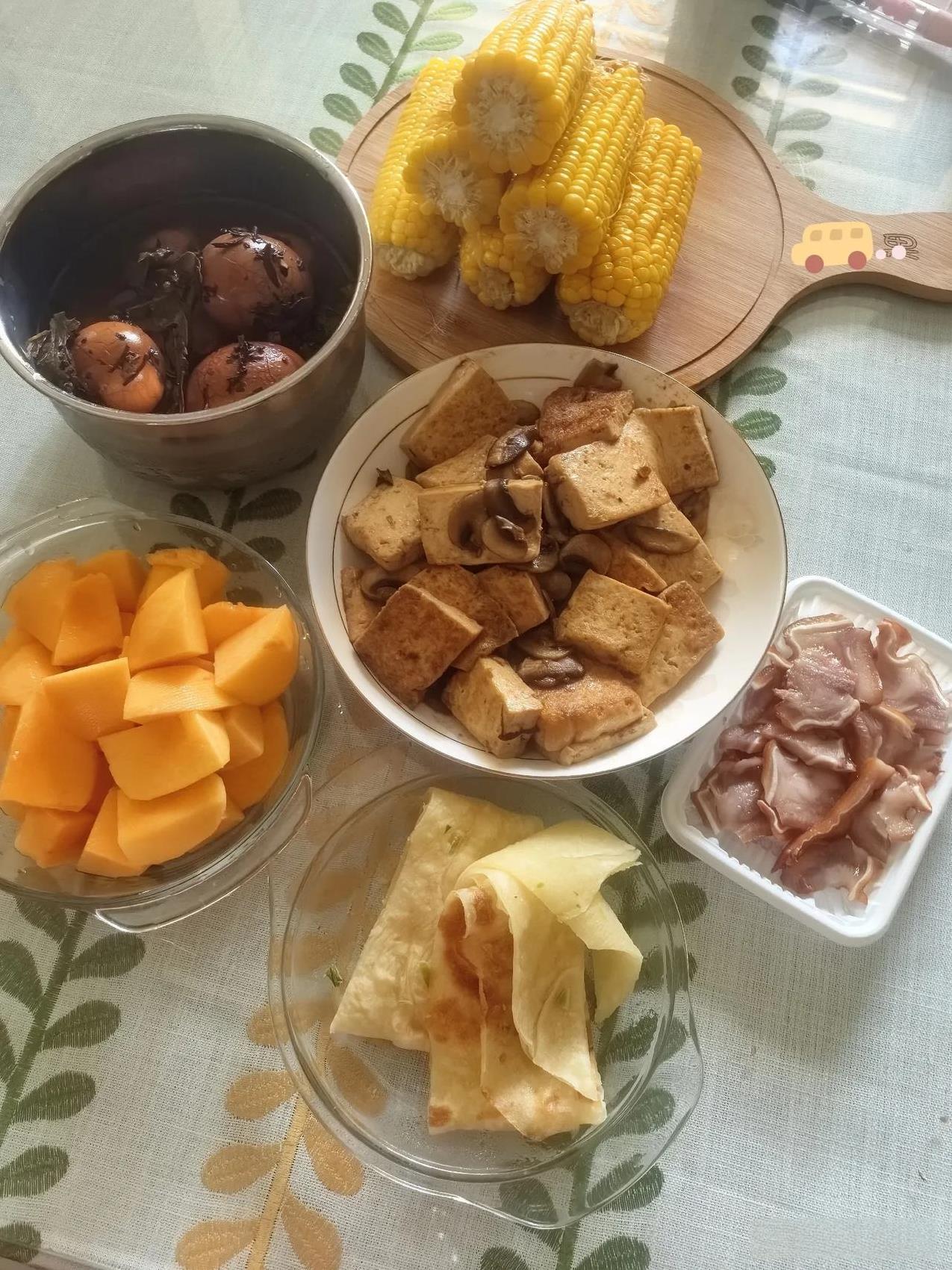 一家三口的早午餐，煮了三个玉米，又做了一个我爱吃的口蘑烧豆腐，还有昨天卤的茶叶蛋