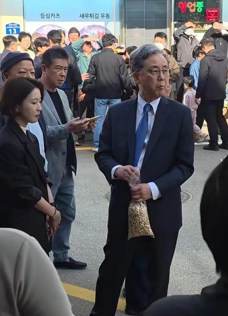 吃爆米花等李在民，可旁边那女的也想吃一口啊，不给安贵玲吃吗？
吃爆米花走在大街上