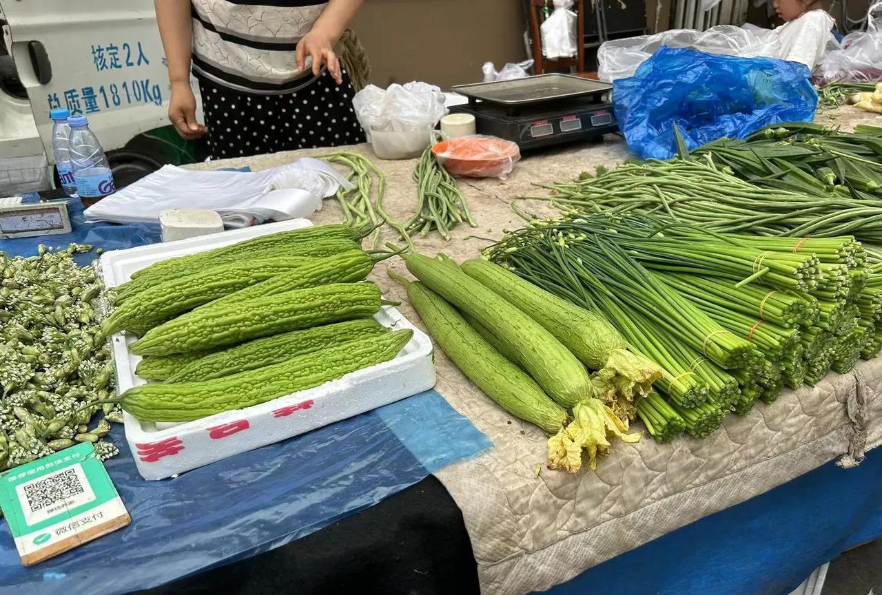 早晨在一个卖菜的摊位前，我选一根长长的绿丝瓜，感觉非常不错，就让卖菜老太太给我装
