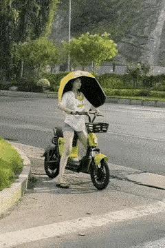 乍一看好像是扛着一把伞，
定睛一看原来是个大号头盔。