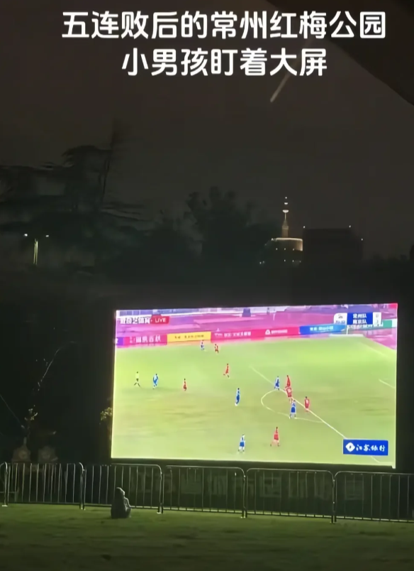 常州比赛完，人群散尽，小男孩雨中看着苏超回放不愿离去

比赛已结束，人群已退散，