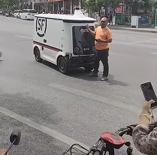 大哥开车被无人驾驶车刚蹭
拦着无人驾驶车不让它走
这种情况要找谁负责