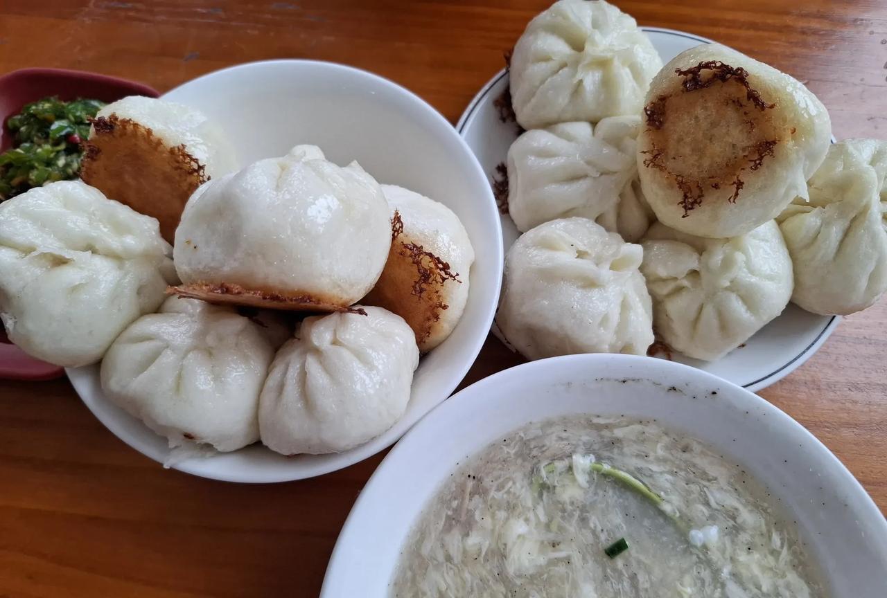 #每日一餐饭食分享#
两盘生煎包，白白的面皮，底部煎得金黄焦脆 ，褶子规整。一旁