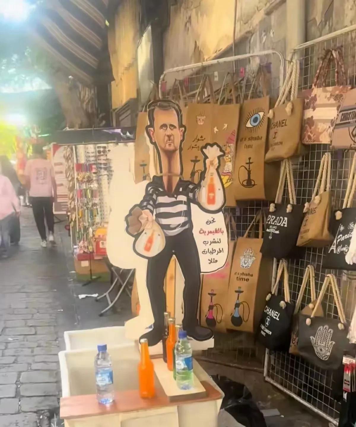 巴沙尔已经走了，可是叙利亚人却忘不了他。还把他的相片做成漫画放到铺位上，还把他的