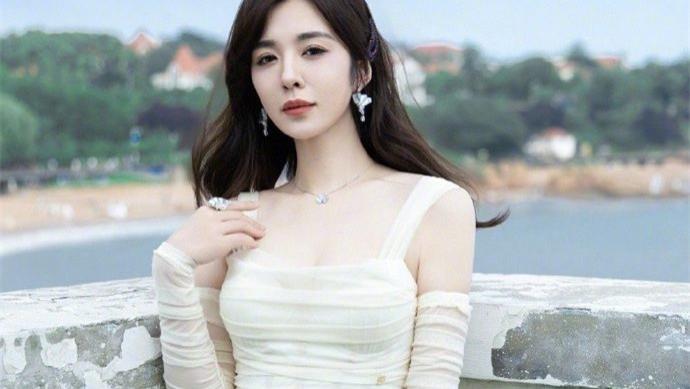 王晓晨穿白色长裙在海天背景中，散发出优雅静谧的迷人气质