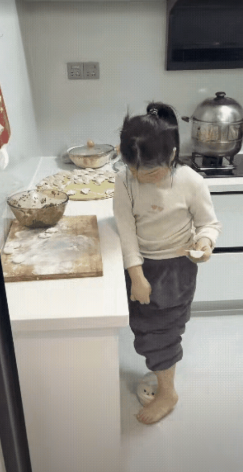 网友震惊了:妈妈拍下女儿在厨房包饺子的一幕，那是手脚并用。只见女儿拿起一个面团丢
