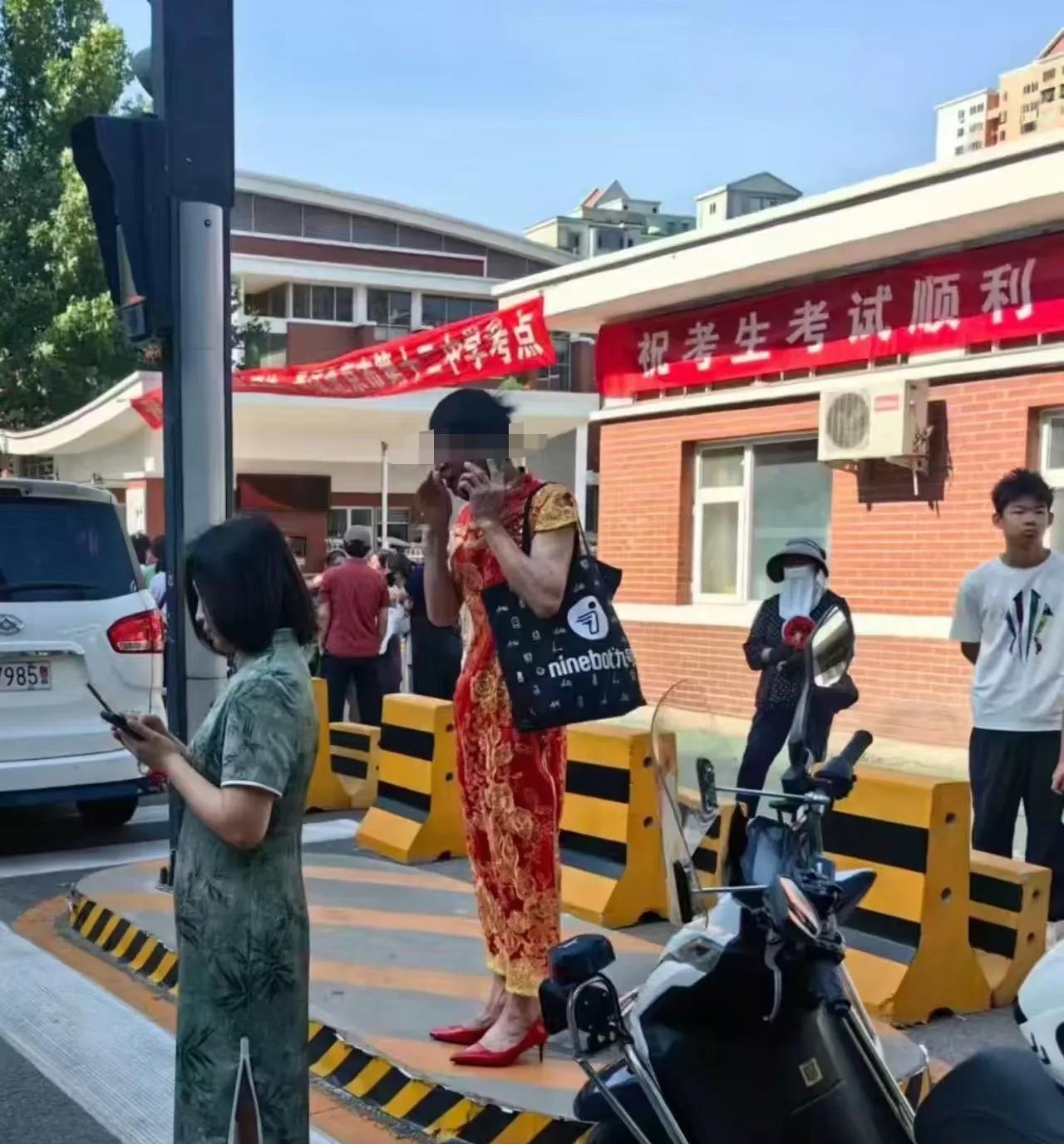 转自网友，十二中考点门外，很多家长身穿旗袍，人群中这位男士为了孩子也是拼了！