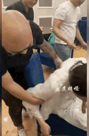 据说这是同学聚会的情景，这位女士被按在椅子上，一位男士往她嘴里塞东西，那根肠好吓