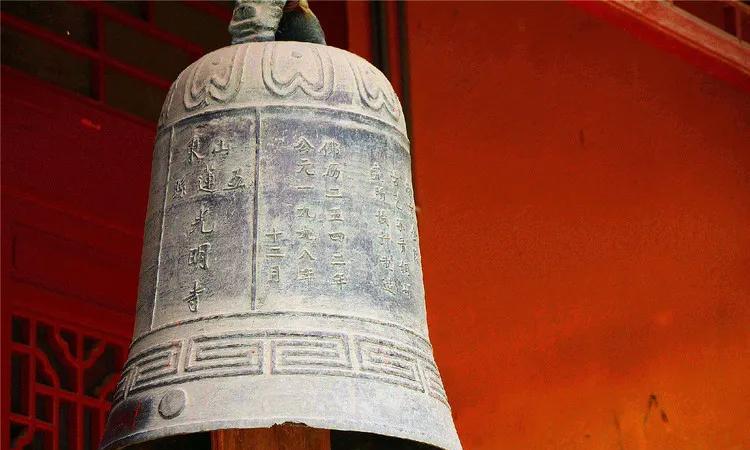 四川成都女子在游览古寺时看到寺面前有一座古钟非常的壮观，她一时兴起，翻过围栏，拿
