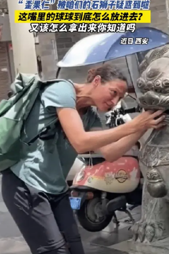 这下解释不清了！西安，一外国女子来旅游，看到一个门前的石狮子，突然被嘴里的石球吸
