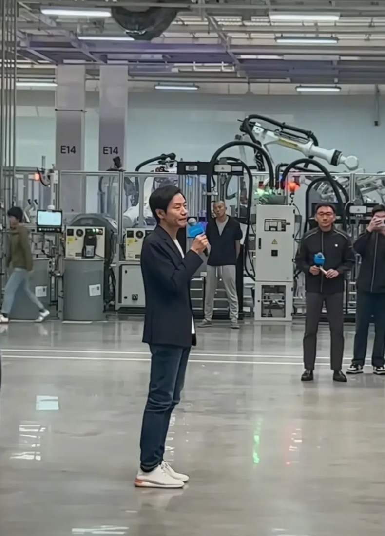 这是雷军在小米公司车间内给生产主管开会时的场景。他拿着话筒，很有耐心的为各位高管