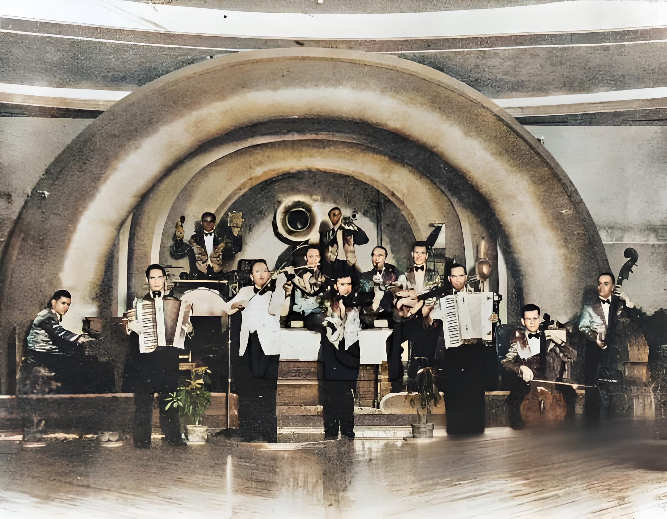 这是一张呈现民国时期旧上海乐队演出场景的黑白照片。画面中，一群身着礼服的乐手组成