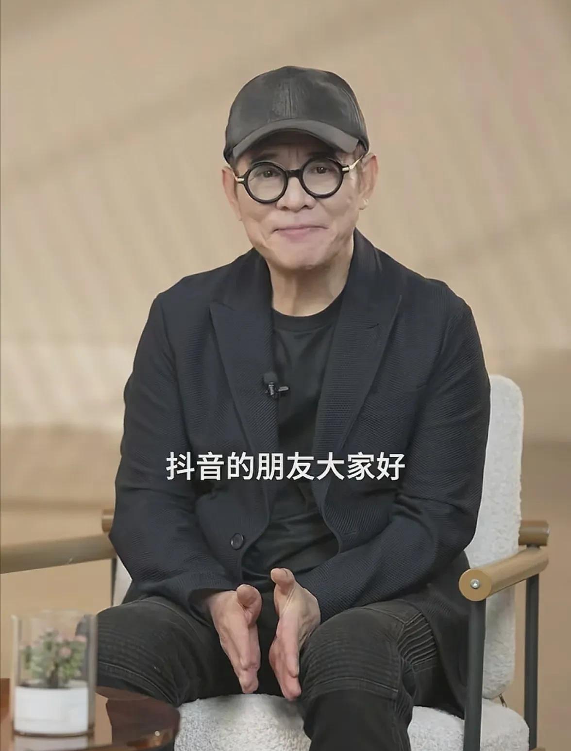哪还是什么功夫皇帝，镜头前就是个穿黑西装、皱纹深刻的老头子，笑得特坦荡。他上来就