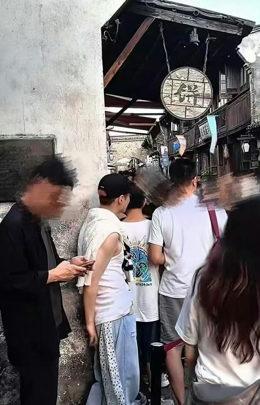 他居然在乖乖排队买包子，穿的也挺随意～  