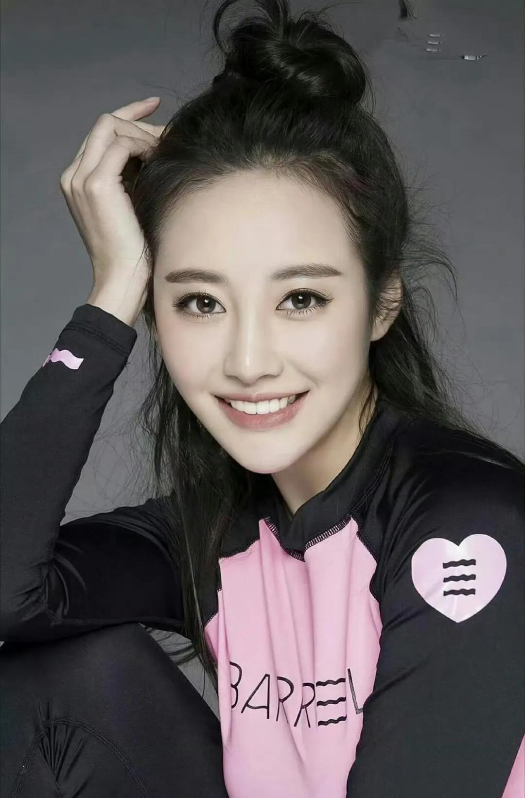 #李纯#粉黑撞色的运动套装，藏着少女的俏皮与活力。高束的丸子头随动作轻扬，甜笑间