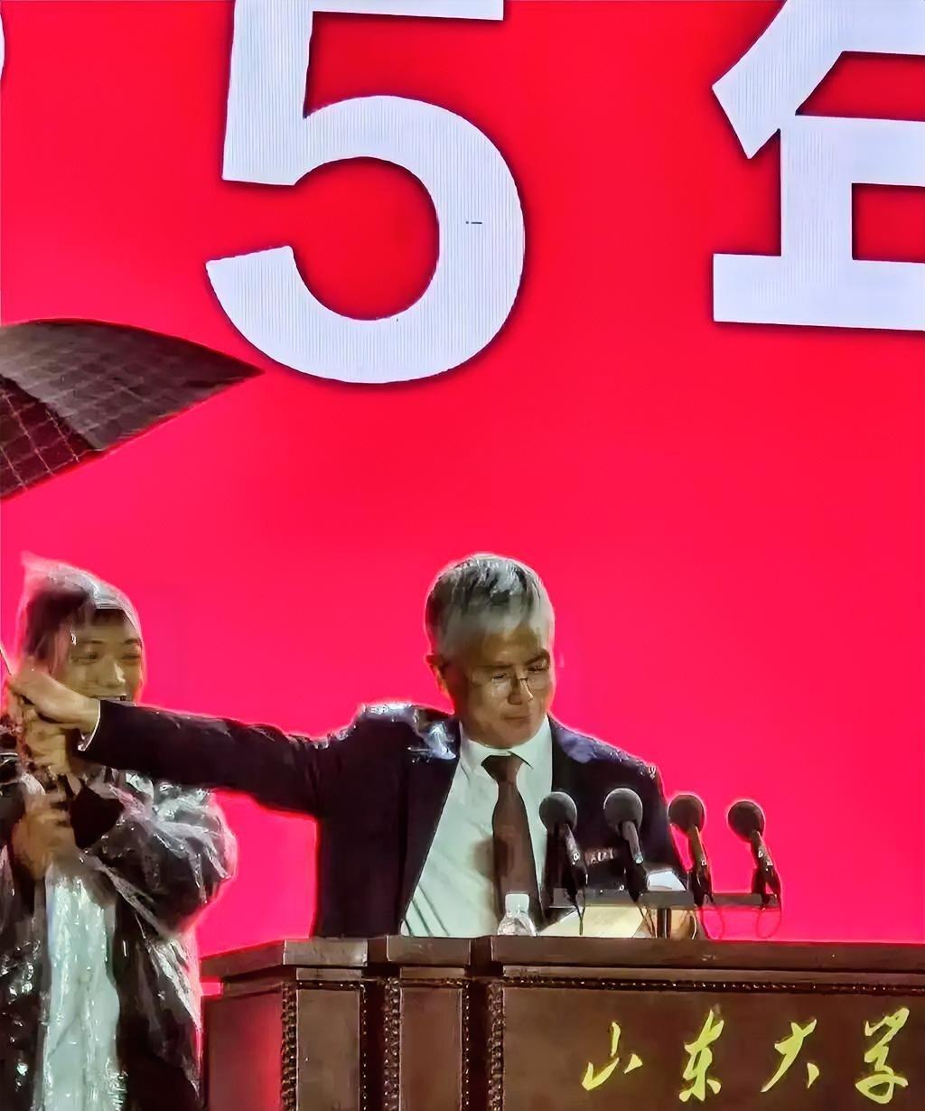 为山大校长撑伞的这位老师，
这位老师或许本是出于好意，想在雨中好好表现，为校长撑