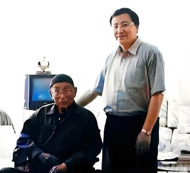 这是2001年百岁的张汉卿与一位戴着眼镜的儒雅男子在一起。很少人知道这位男子的身