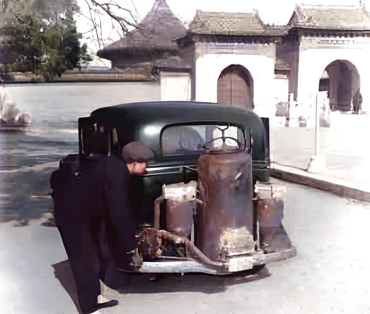 1950年，北京一个景点门口，停着一辆奇怪的轿车。车尾部安装着三个圆柱形的物体。