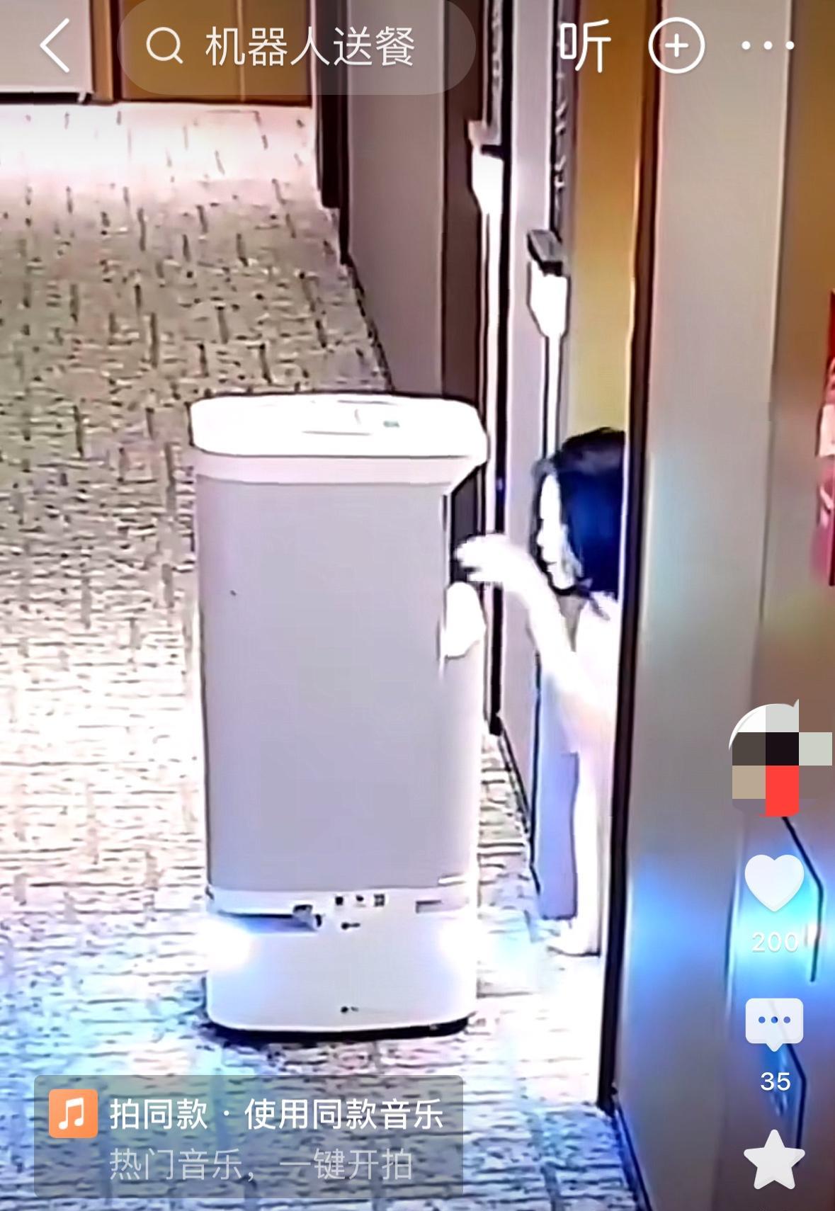 某酒店走廊视频监控，机器人来送餐，客房里一个女的举动怪异，爬出来取餐，第一次用嘴