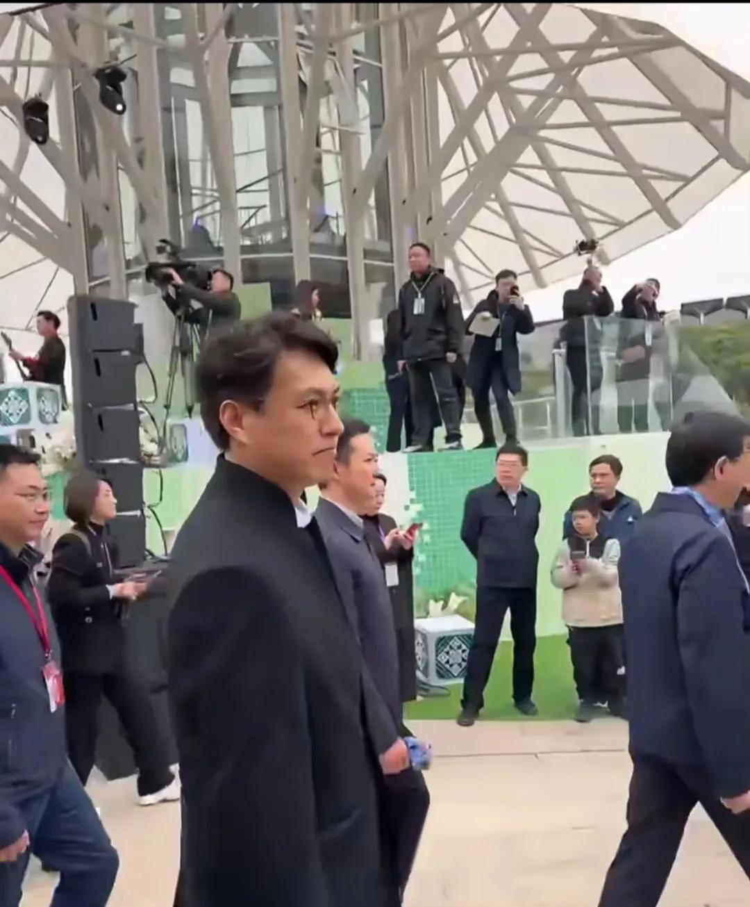 靳东现身南宁民歌湖，出席“广西三月三”开幕式，白衬衫配呢子大衣，眼镜一戴比领导更