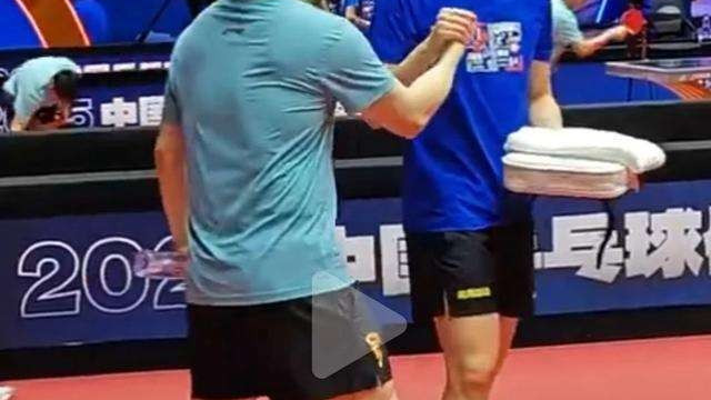 乒超赛场王楚钦主动与樊振东击掌打招呼，击掌后两人都开怀大笑