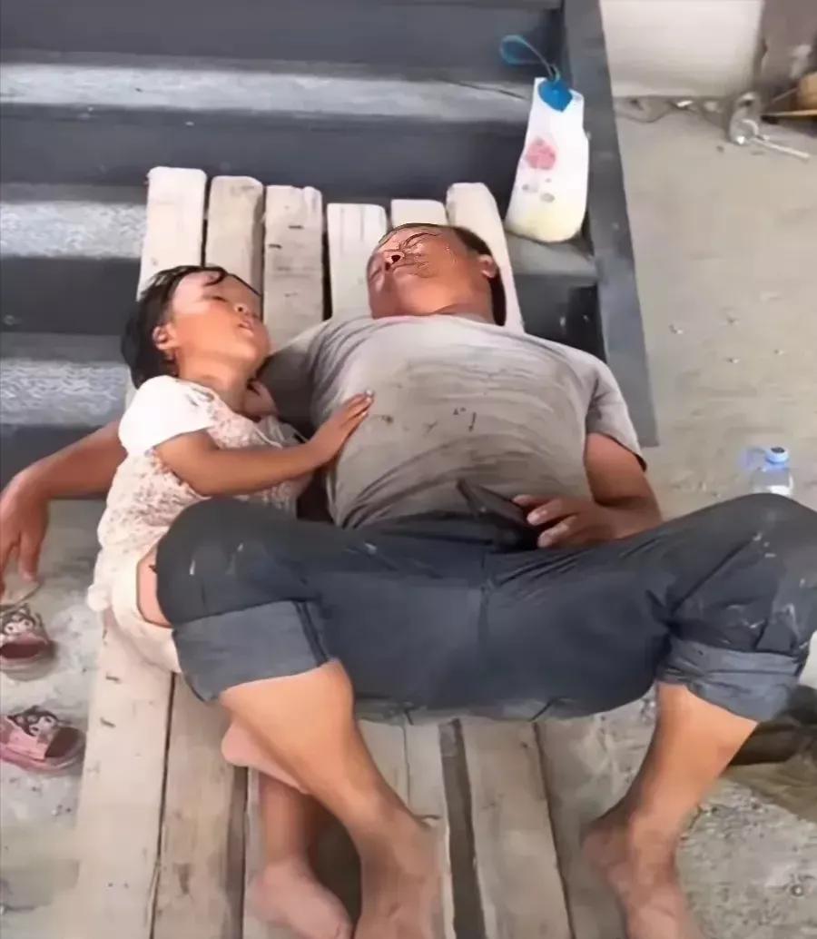 一位父亲，搂着女儿睡在木板上，天气很热，空气很潮湿，他们却睡的很香。
有人说，我