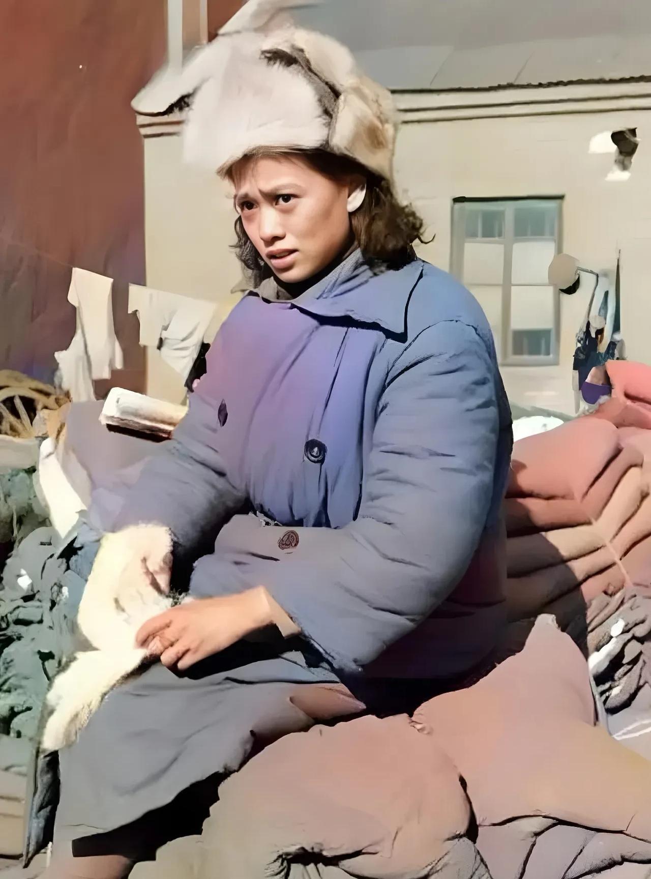 这是1948年，淮海战役时期，一名年轻的国军女兵，坐在堆积如山的军用棉衣棉被上，