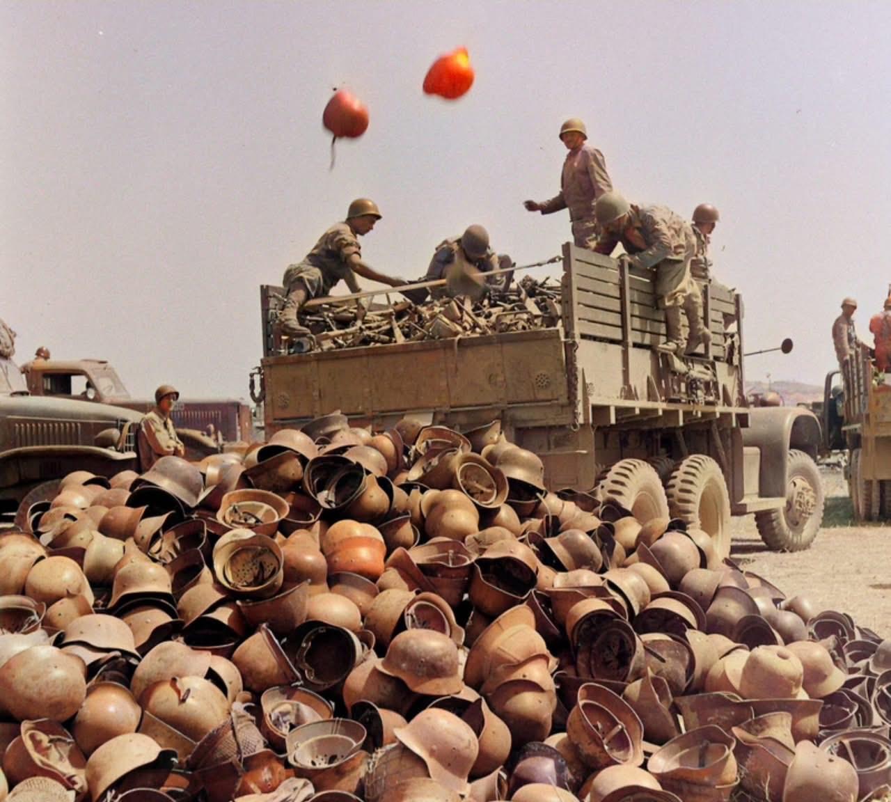 1943年5月，北非战场，突尼斯战役之后，盟军正将缴获的轴心国钢盔运输至某处堆存