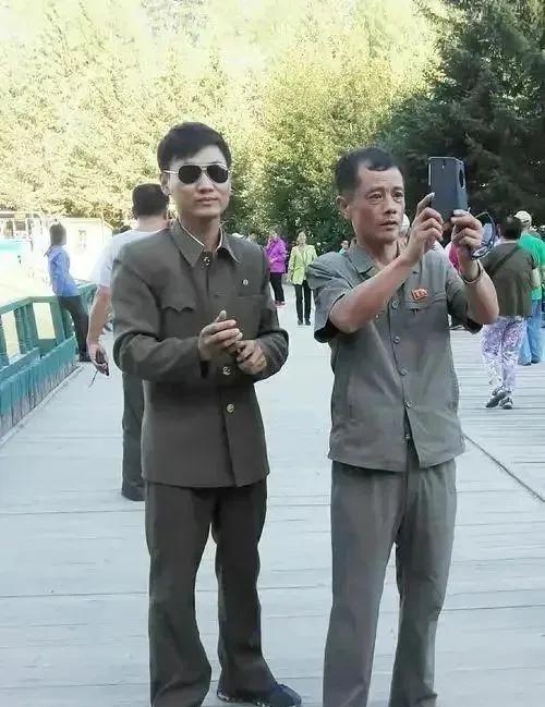 朝鲜街头上的男子众生相
图中：这位青年可称为帅哥了，右图：这位男子使用二部手机，