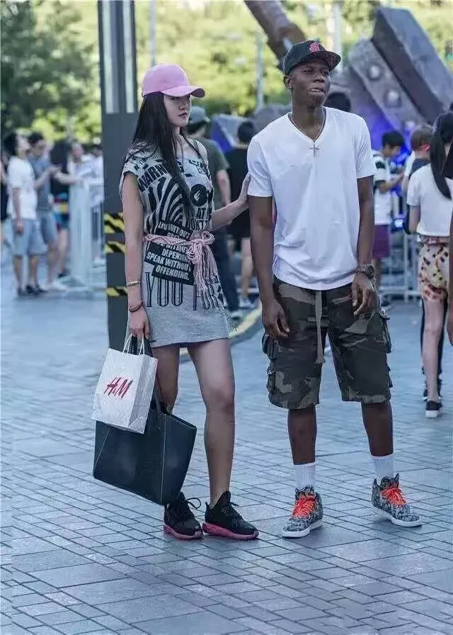 扎心！在广州街头看到有一位高挑靓丽的女子跟她的黑人男友在逛街，这名女子身高大约1