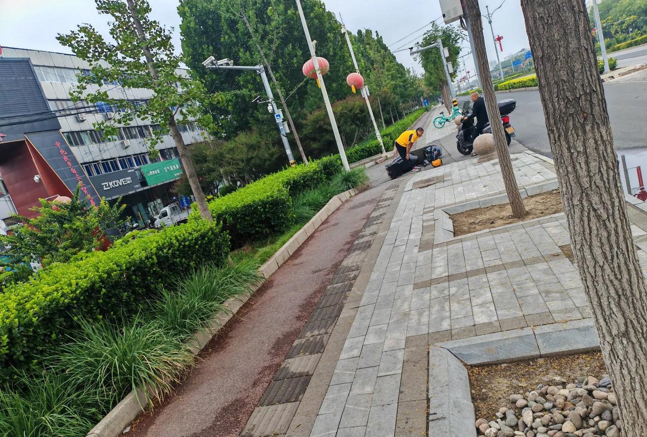上午，良乡建材城门口，这外卖小哥从这个市场出来，开的太快又是上坡拐弯，摔得够疼，