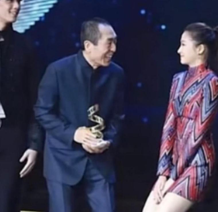 一次颁奖晚会上，张艺谋走向关晓彤时，只见她双腿紧闭，双手捂裙，双膝往下蹲。张艺谋