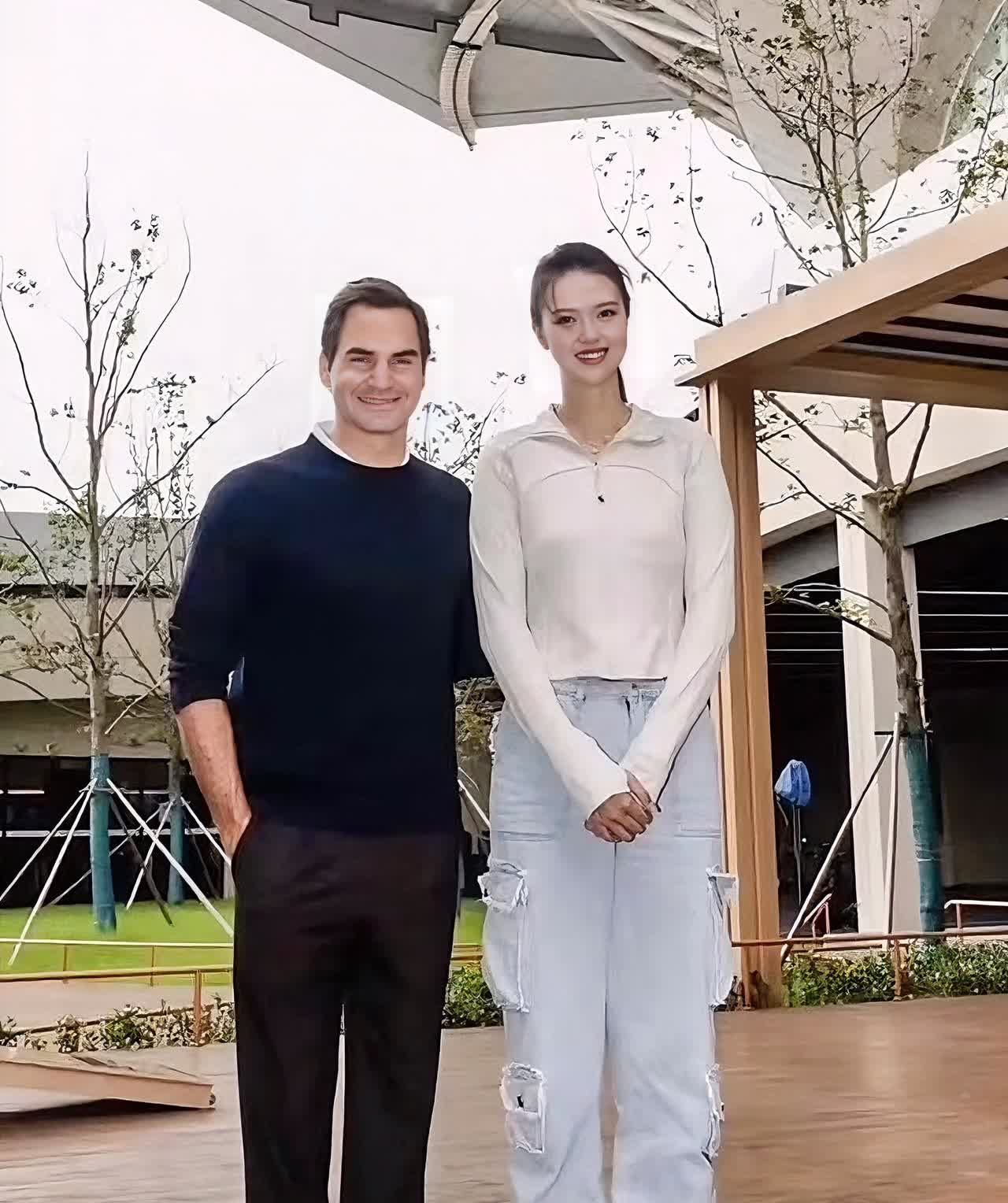 张常宁与费德勒的户外合影，背景有现代建筑和绿植。一个是中国女排队员，一个是网球名