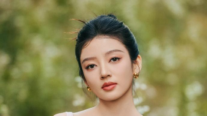 何瑞贤的高挽扎发吊带长裙，优雅静谧之感