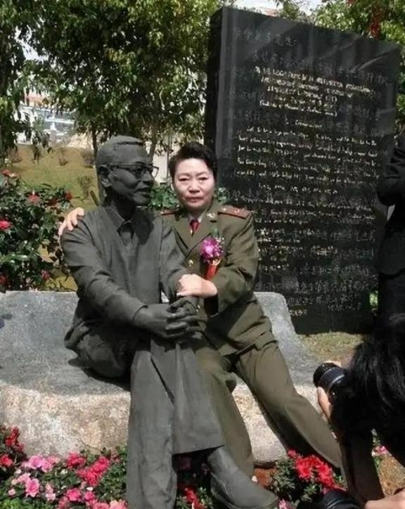 1997年，陈景润的妻子坐在丈夫的雕塑旁，紧紧搂住“丈夫”的肩膀，留下了这张感人
