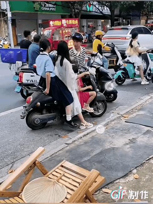 戴头盔的这个骑车女人太有点嚣张跋扈了，因为一点小事，就在热热闹闹的马路边，开始对