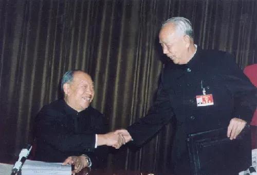 彭真和万里两人在主席团会议上的亲切握手。
