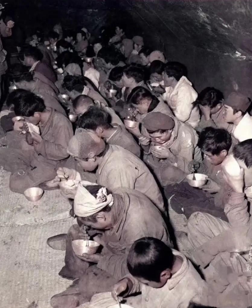 1952年，韩国，美军战俘营内，一群被俘的战士们正在用餐的场景，他们当中既有志愿