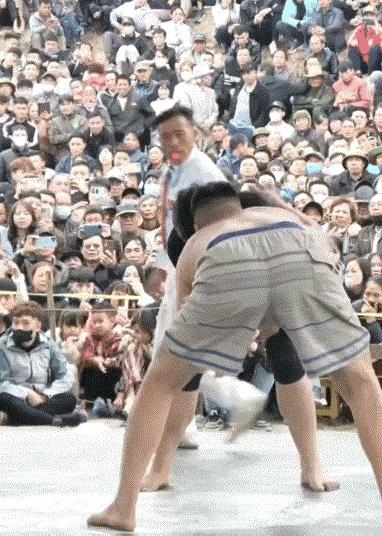 乡村业余混合男女摔跤比赛，最后男方以不方便为由放弃比赛，裁判判定女方获胜。