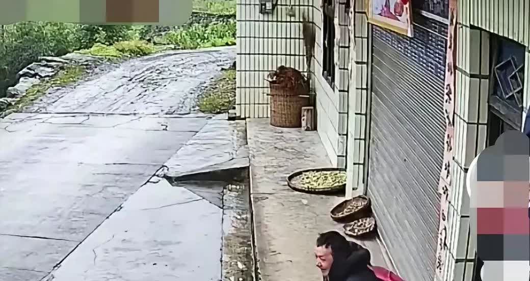 这位男子在人家走廊上避雨，坐在凳子上看着外面的雨水，心里不知在想什么，等雨停了，