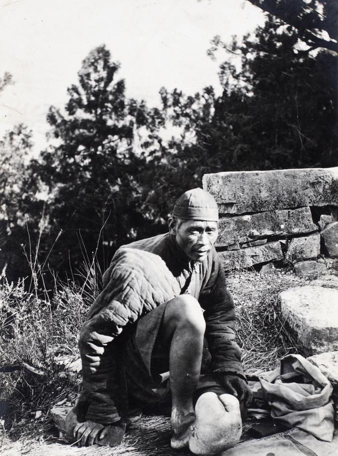 1920年，一名男子坐在路边，面前的地面上摆着一块布，上面有几枚硬币。可是，最让