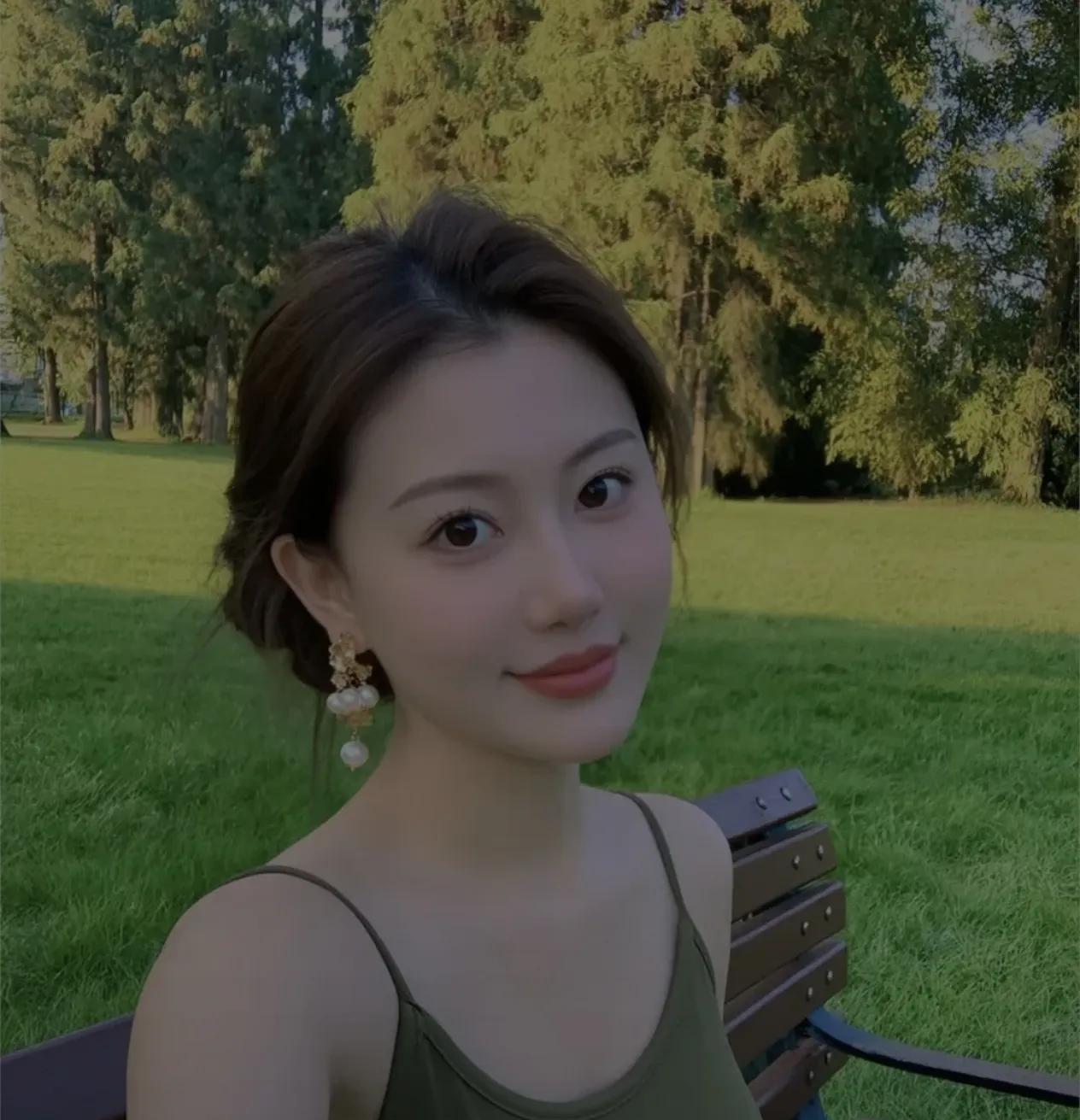 阳光下，绿意盎然的公园，微笑的少女，静谧而美好。