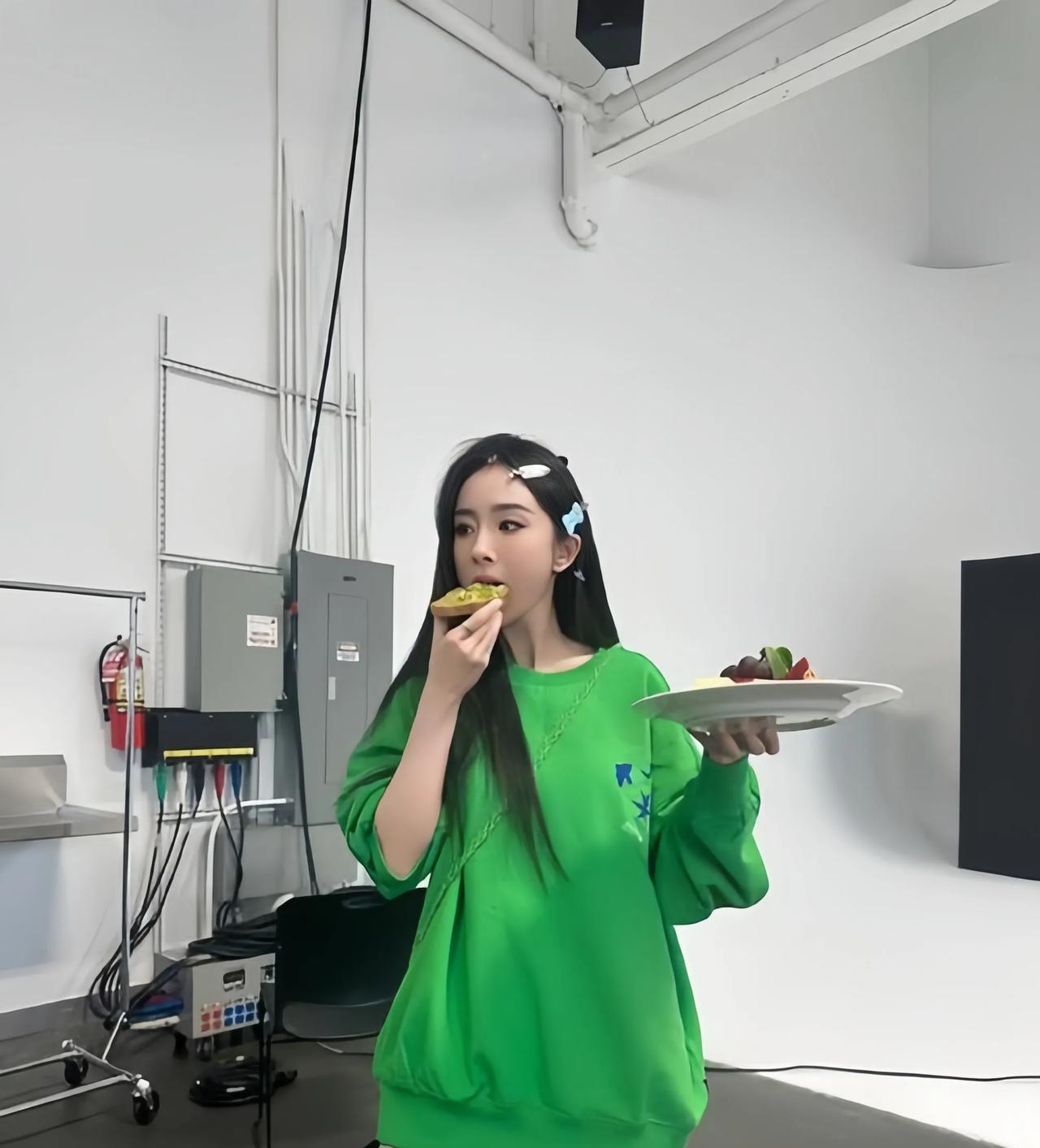 杨幂的性格真的超好，这是一组她吃美食的画面。
杨幂身穿绿色卫衣搭灰色毛呢短裤，一