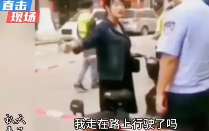 某个城市里，一群交通管理人员将一名女子围在中间，旁边还跟着一辆拖车。原来，这些身