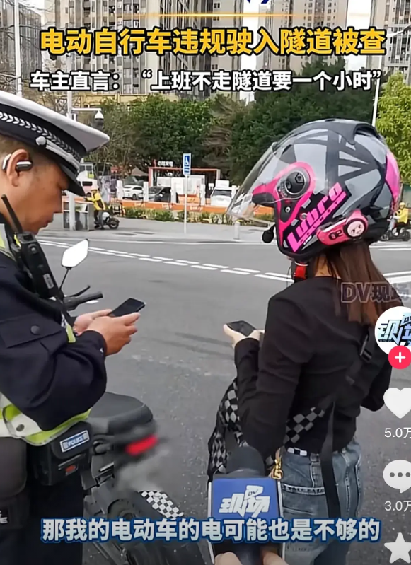 这个骑电鸡的女士，违规驶入广州市车陂南隧道，被执勤民警捉个正着，在检查证件准备开